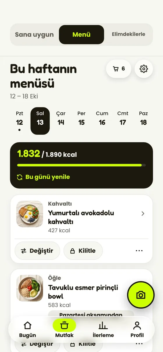 Uygulamanın haftalık menüsü: bir günün öğünleri, kalorileri ve her birinde Değiştir ile Sabitle.